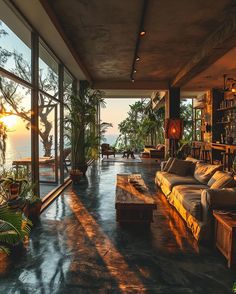 a living room filled with lots of furniture next to a large glass window overlooking the ocean