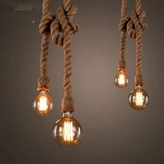 three light bulbs that are hanging from rope