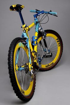 a yellow and blue bike is shown against a gray background