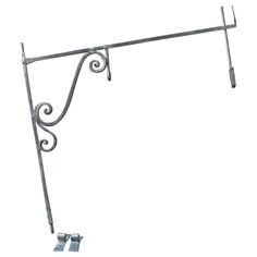 an iron shelf with two hooks on it