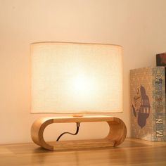 a table lamp sitting on top of a wooden shelf next to a bookshelf