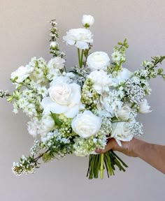 a person holding a bouquet of white flowers