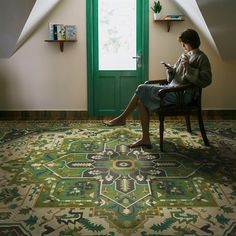 a woman sitting in a chair looking at her cell phone