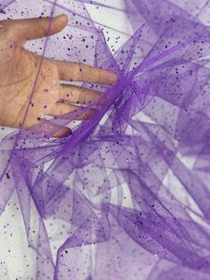 This is purple glitter on tulle. The fabric has shiny and sparkly look because of the glitter. The fabric serves multipurpose and can be used for dresses, gowns proms, decor, and many more.  PLEASE NOTE : Although there is no compromise with the quality of the fabric, some might notice falling off the GLITTER while handling, which is quite common with these kinds of fabric. CLR: Purple WIDTH: 60/62 INCHES                   LENGTH : 36 INCHES (1 YARD) CONTENT/COMPOSITION: Polyester 100% USAGE: Bridal & Wedding Dress, Evening Gowns, Partywear, Prom, Costume, Décor, Hair Accessories, Bags, DIY CARE INSTRUCTIONS:  Wash gently. Hand wash whenever possible. Avoid machine wash if you can. Wash items in cool water. Avoid extreme heat. If possible Dry Clean.  Please note image colors may vary per s Kinds Of Fabric, Gown Prom, Dress Gown, Purple Glitter, Bridal Wedding Dresses, Event Decor, Evening Gowns, Violet, Hair Accessories