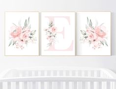 two pink flowers are hanging on the wall next to a crib with a baby's bed