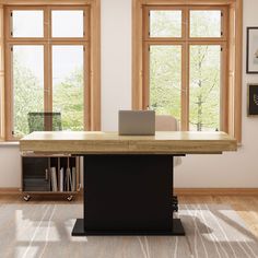 a desk with a laptop on it in front of two large windows and a bookcase