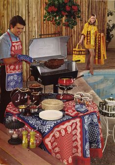 two people in aprons are preparing food near a pool with a grill and table cloth on it