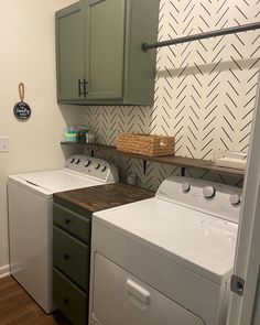 a washer and dryer in a small room with green cabinets on the wall