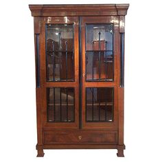 a wooden display cabinet with glass doors