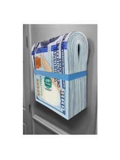 a roll of money hanging from the side of a door with blue tape on it