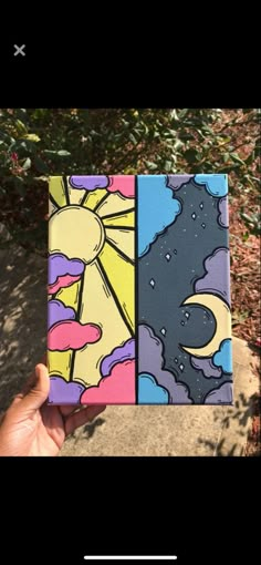 someone is holding up a small box with an image of the sun and moon on it