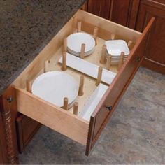 an open drawer with plates in it on the counter and another box containing empty plates