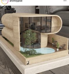 an architectural model of a house with a pool and living room in the middle is displayed on a wooden table