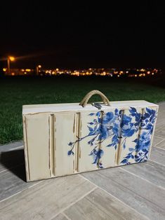 a blue and white box sitting on top of a wooden floor next to a green field