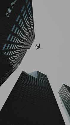 an airplane flying through the sky between two tall buildings