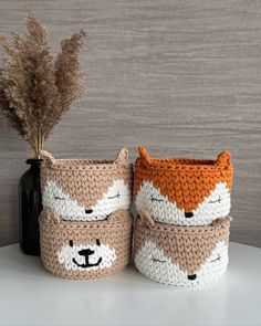 two crocheted baskets with animals on them, one has a plant in it