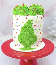 a decorated cake with green frosting and sprinkles on a red plate