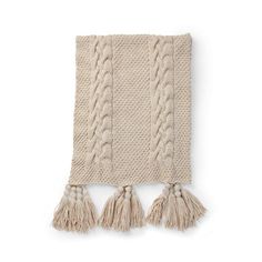 a beige blanket with tassels on it