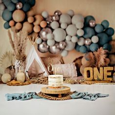 a cake sitting on top of a table next to balloons