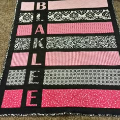 a black and pink quilt on the floor with words that spell out what to do