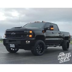 a large black truck parked on top of a parking lot