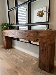 a wooden table sitting in front of a mirror on top of a hard wood floor