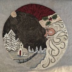 an embroidered christmas ornament with santa's sleigh and trees on it