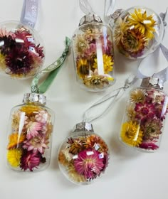 four glass vases filled with dried flowers