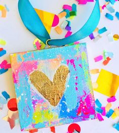 an art project with confetti and streamers on the ground, including a gold heart