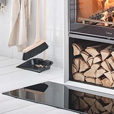 a fireplace with logs in it and a broom on the floor