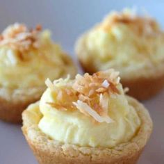 three cupcakes with white frosting and toppings on top are sitting on a plate