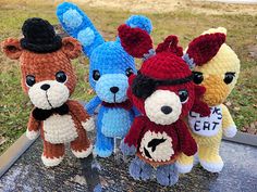 four crocheted stuffed animals sitting on top of a table