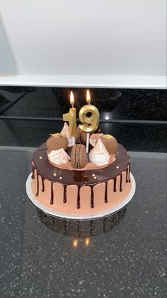 a birthday cake with chocolate icing and lit candles