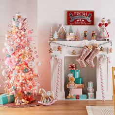 a pink christmas tree with candy canes and other decorations in front of a fireplace