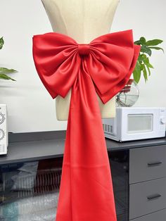 a dress form with a large red bow on it's back and necktie