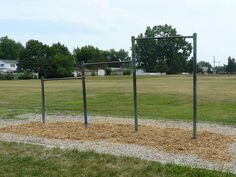 an empty park with some kind of equipment in the middle and grass on the other side