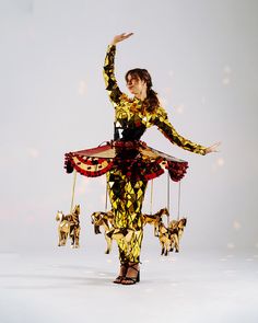 a woman is dressed up in an elaborate costume and holding her arms out to the side