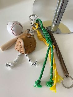 a baseball bat, ball and keychain on a table