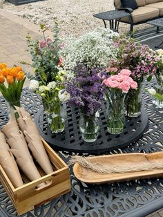 a table topped with vases filled with flowers on top of a metal table cloth