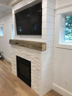 a flat screen tv mounted on the wall above a fireplace