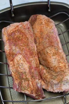 two steaks sitting on top of a grill in a frying pan next to each other