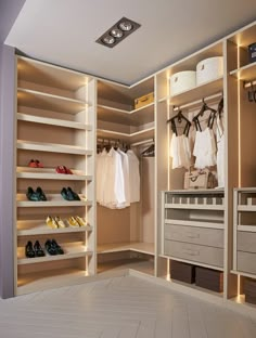 a walk in closet filled with lots of shoes and clothing hanging on the wall next to drawers