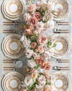 a table with plates and flowers on it