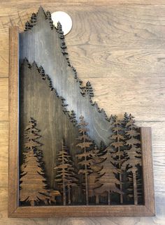 a wooden clock with some trees on it