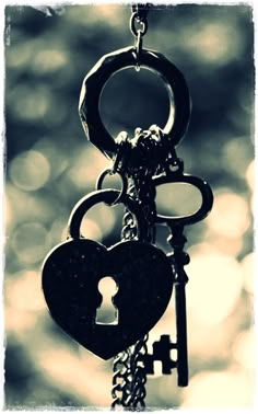 two keys are attached to a chain with a heart shaped key on it's end