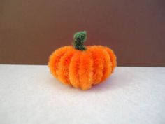 a small orange pumpkin sitting on top of a table