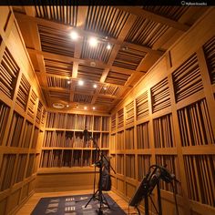 an empty recording room with microphones and sound equipment on the floor in front of wooden bookshelves