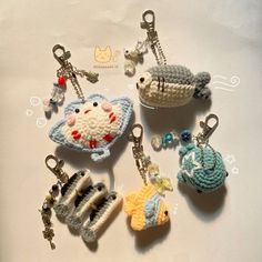 several crocheted keychains are arranged on a white surface