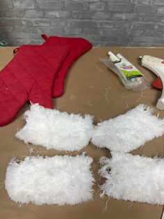 some white fluffy pieces of fabric sitting on top of a table next to a pair of scissors