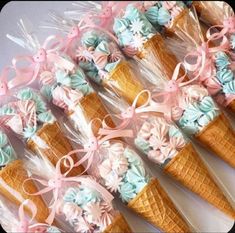 ice cream cones decorated with pastel blue, pink and white flowers are arranged in rows